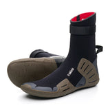 A pair of black wetsuits or neoprene ankle boots with brown textured soles and a red inner lining, displayed on a clean white background. with white branding saying 'c-skins'